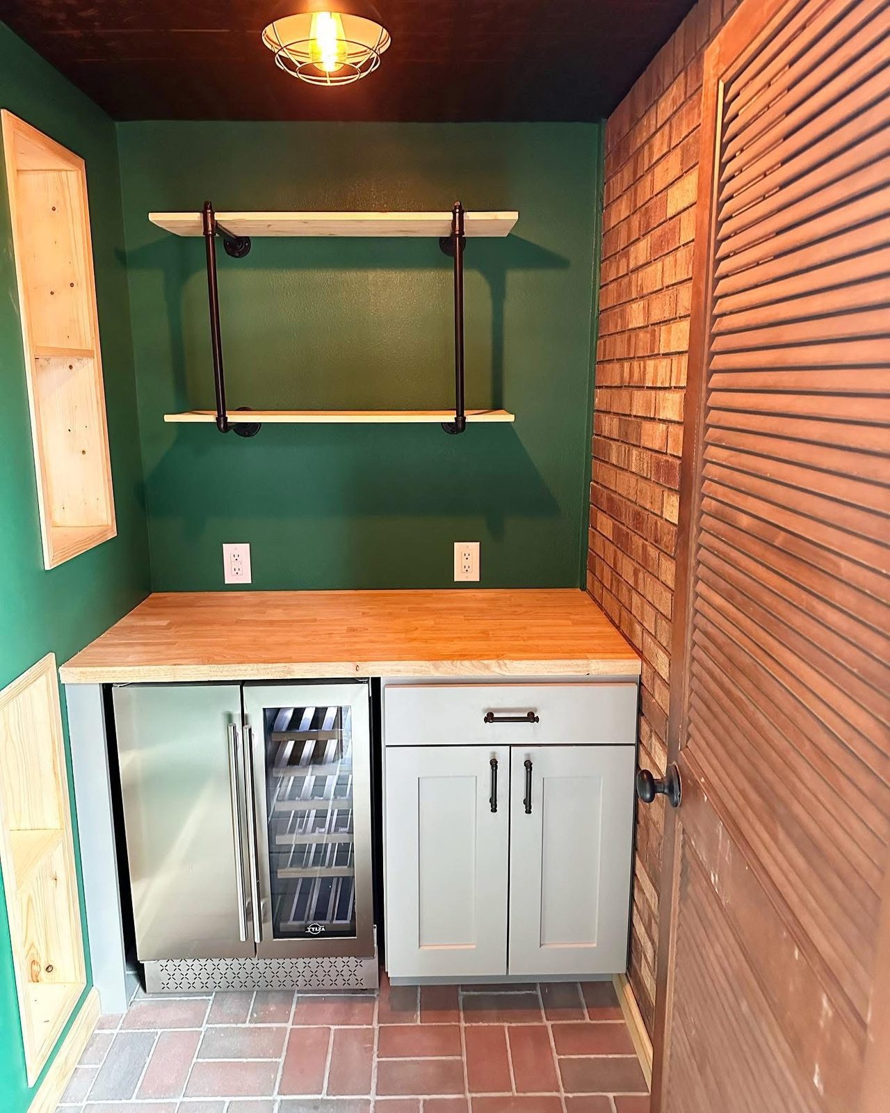 Built-in wet bar with a butcher-block counter, shaker cabinets, a beverage fridge and open shelving on black brackets
