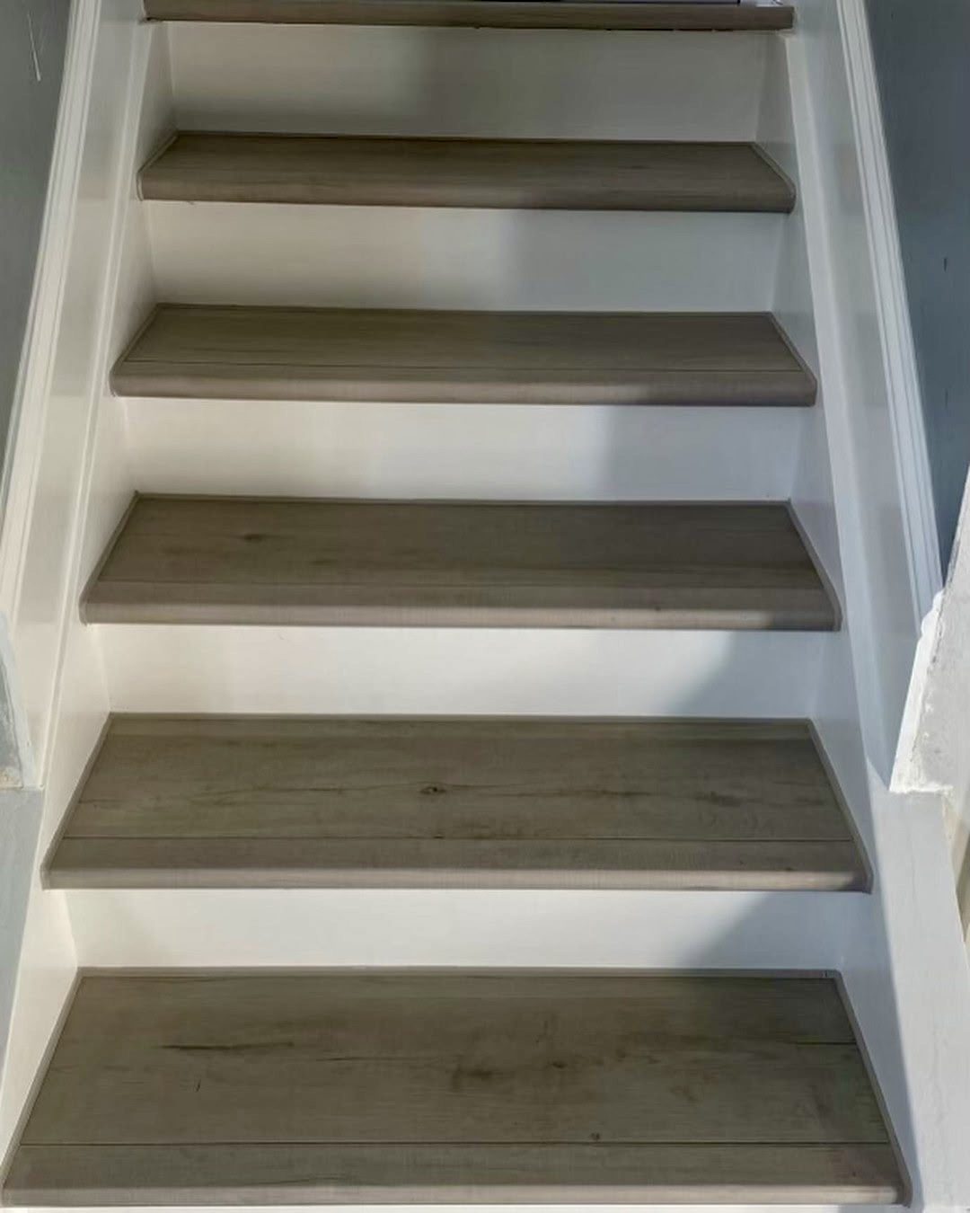 Stair treads clad in vinyl plank with painted white risers