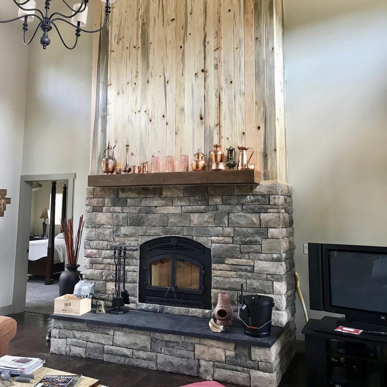 Stone fireplace with a timber mantel and a reclaimed wood chimney breast