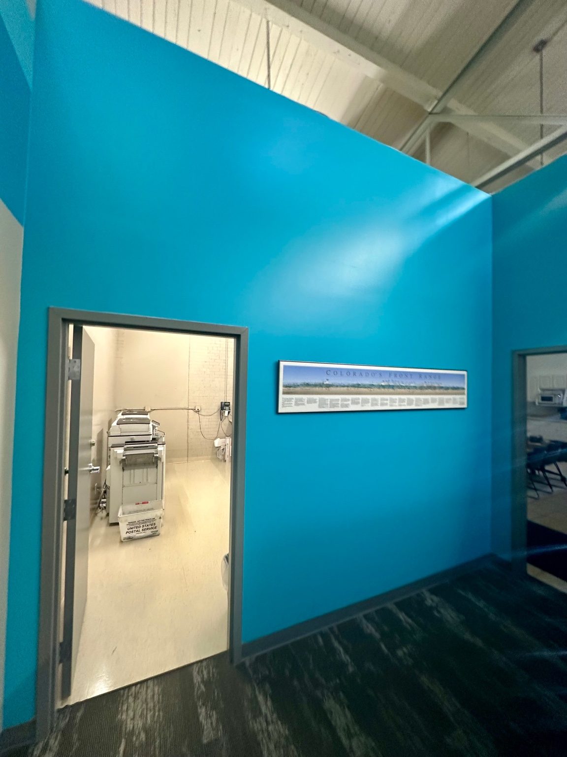 Refinished commercial corridor with a sloped ceiling, new door and dark resilient flooring