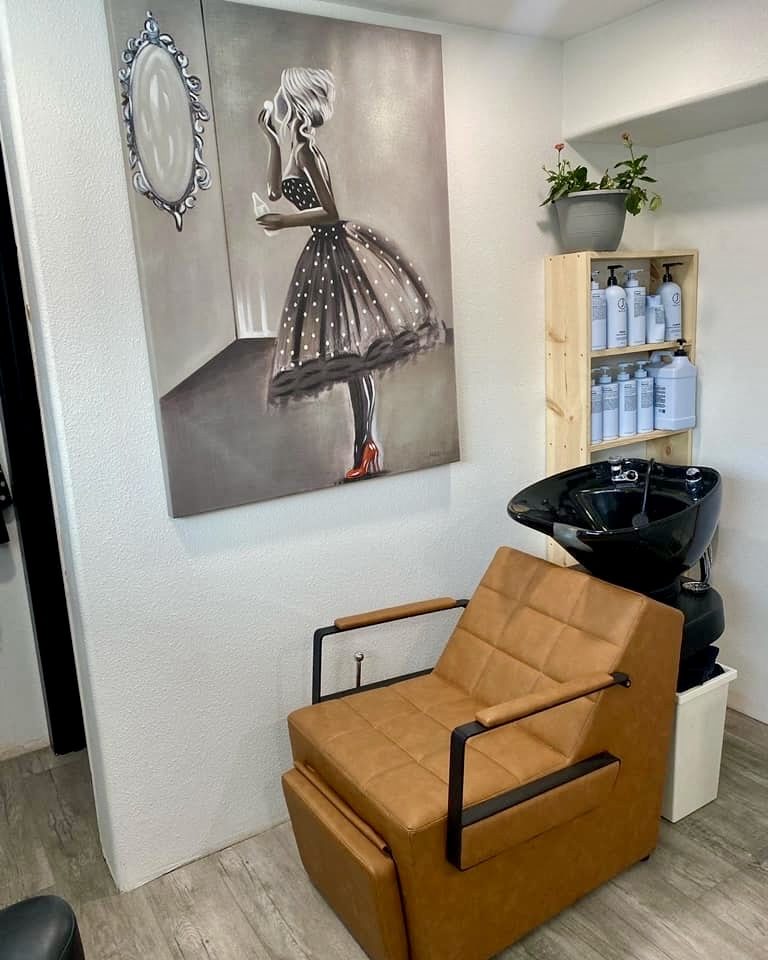 Shampoo station with a black basin, reclining chair and a timber retail shelf