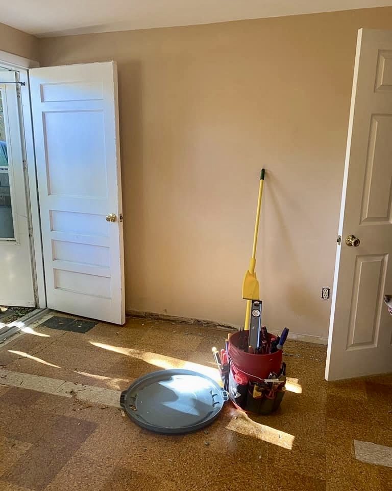 Stripped commercial room before new flooring, original tile and painted walls still in place