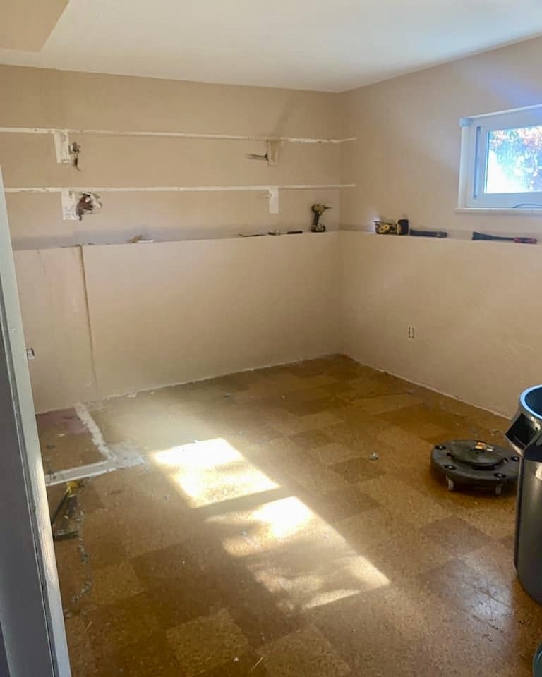 Commercial unit stripped back — casework removed, wall scars exposed, original vinyl tile still down