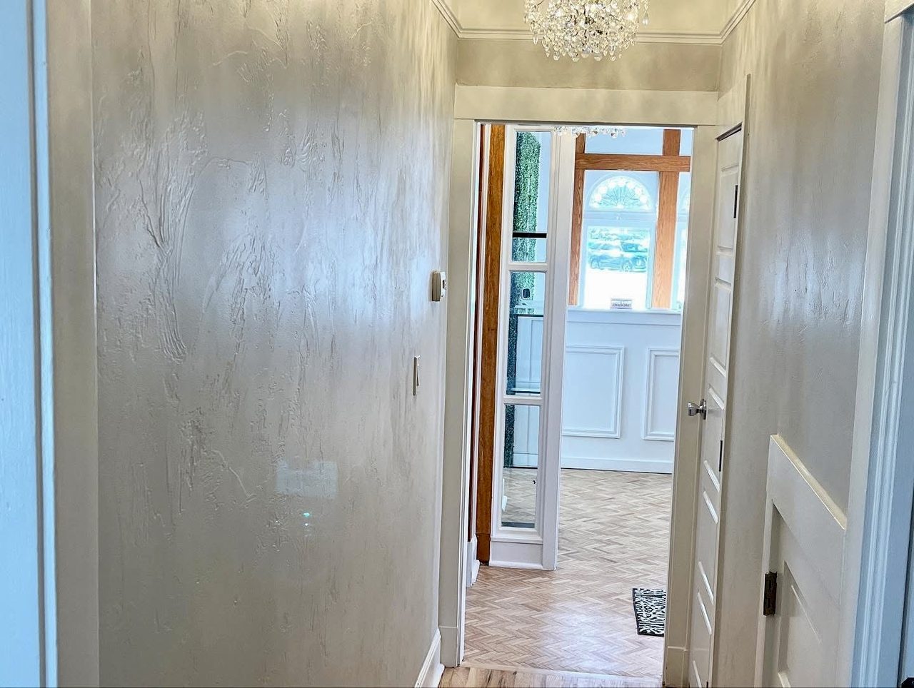 Hallway finished in textured plaster, looking through to the reception area