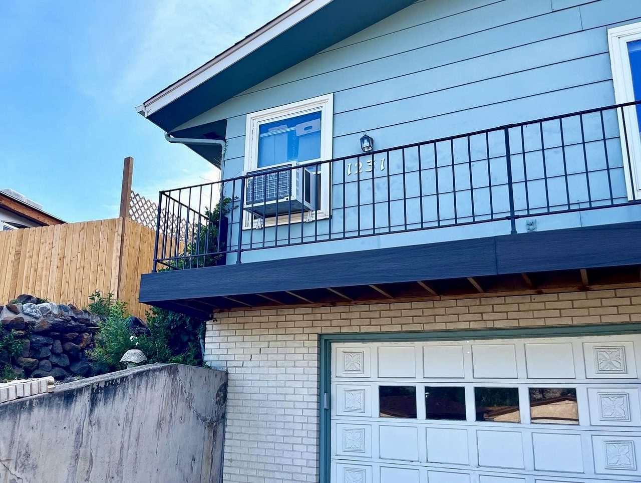 Upper-level deck with black metal railing above an attached garage