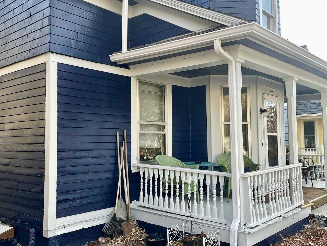 Navy blue clapboard exterior with white trim and a covered porch with turned balusters
