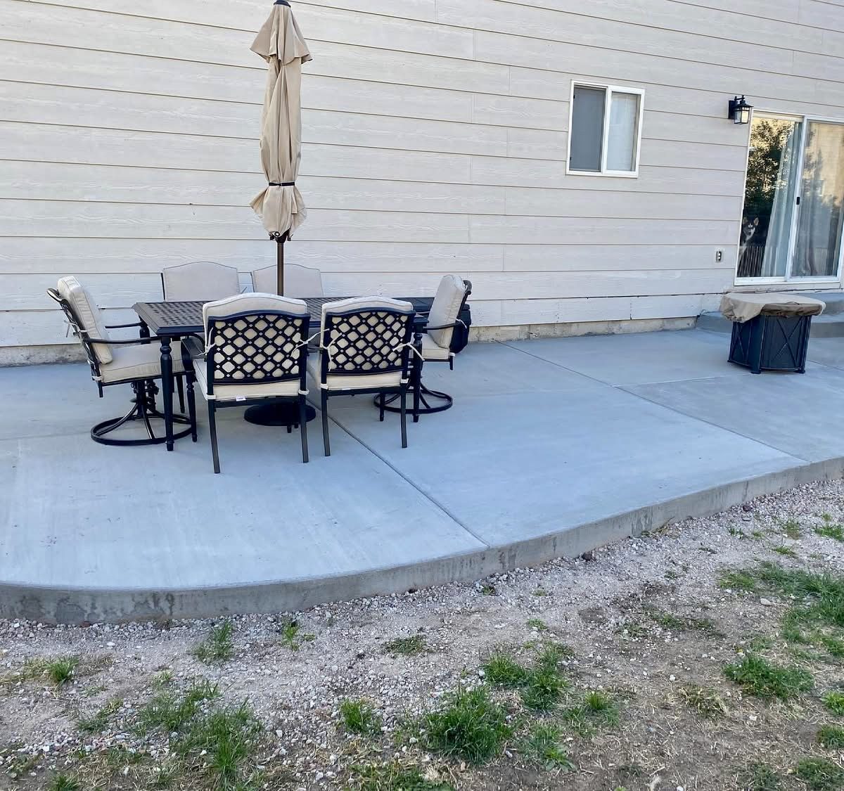 Curved concrete patio with outdoor dining furniture